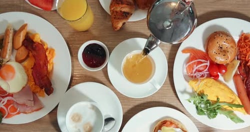Lavish breakfast spread overhead shot pouring tea