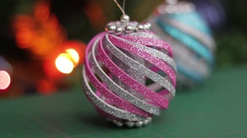 Pink and blue glitter foam christmas ornaments, on a green cutting mat. Beautiful Xmas decorations.