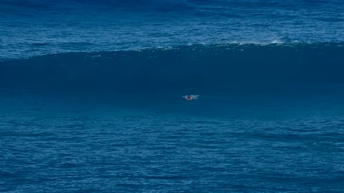 Surfer rides big ocean wave at Jaws