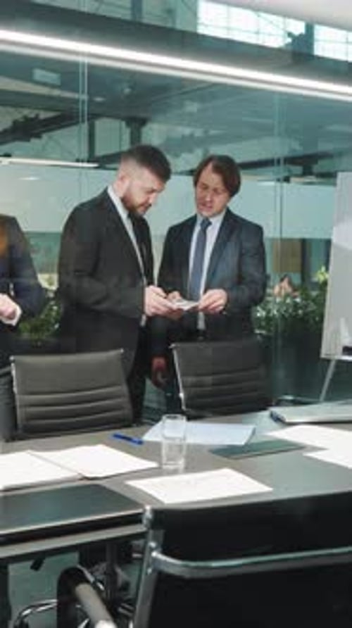 Businessmen Reviewing Data on Tablet in Modern Office