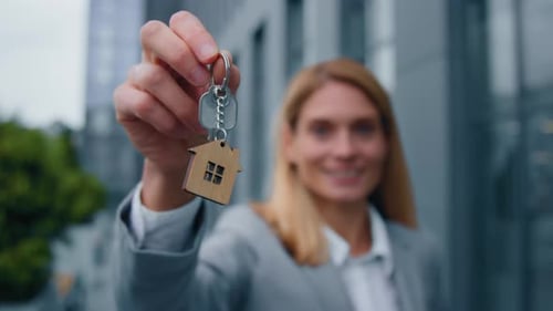 Woman Holding House Key in City