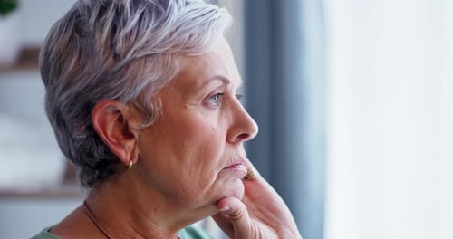 Senior Woman Looking out of a Window