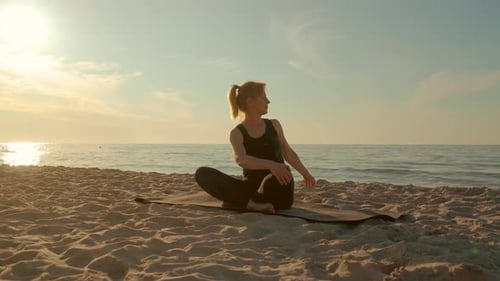 Woman Doing Yoga on Beach at Sunrise