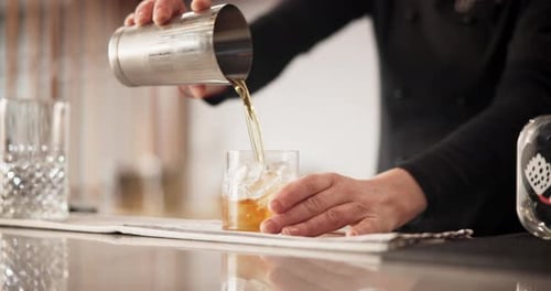 Bartender Making Cocktail with Ice and Lemon