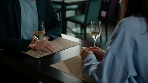 A date in a hotel restaurant a man and a woman drink white wine in glasses the face of smiling girl