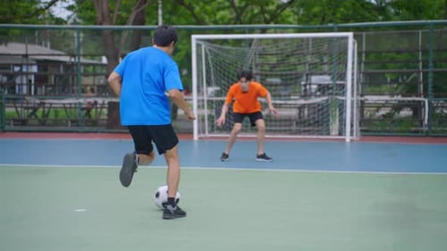 Asian two sportsman practicing football playing in the outdoors stadium.