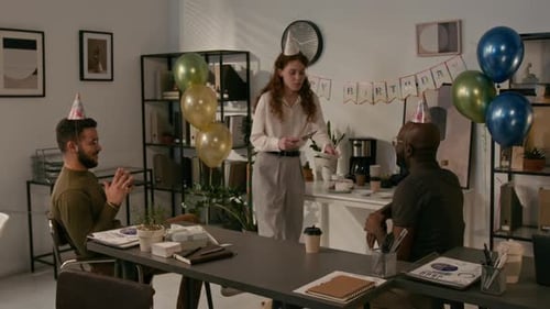 Coworkers Celebrate Birthday with Cake and Party Hats