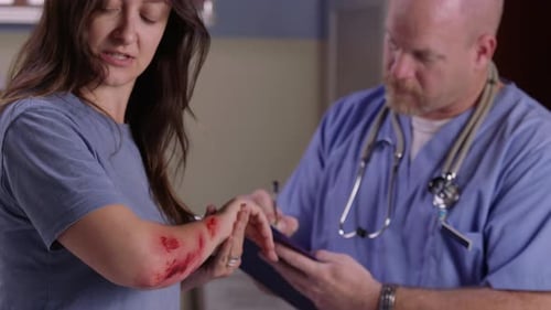 Young woman with arm injury receives medical attention in hospital emergency room