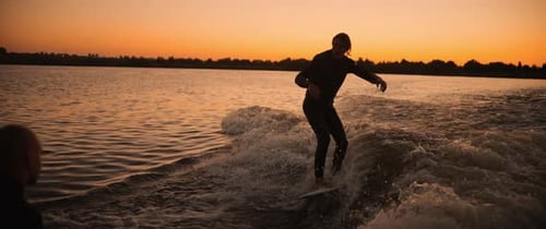 Sesión nocturna de surf Experimenta la emoción de surfear olas al atardecer con amigos haciendo presentaciones