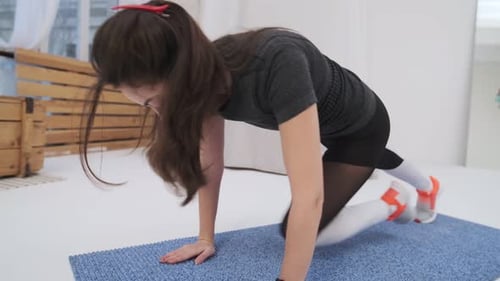 Fit Woman Exercising Indoors on Yoga Mat
