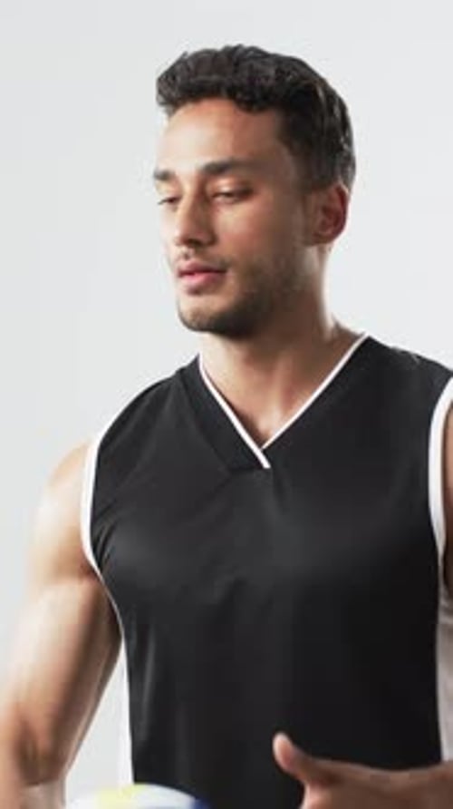 Young Man with Volleyball Bouncing in Studio