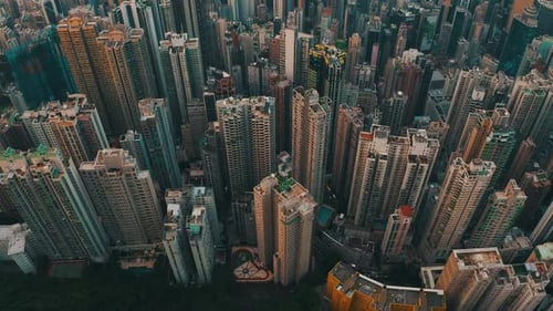Cinematic drone shot of a city with a lot of skyscrapers during the day. There is many roads with tr