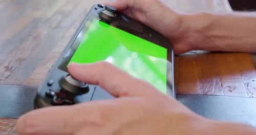 A Steam Deck handheld video game system with a green screen display, perfect for inserting custom fo