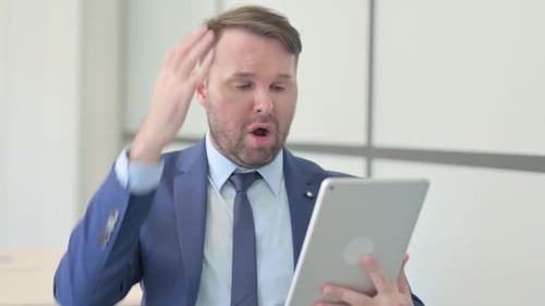 Man in Suit Looks Relieved While Using Tablet