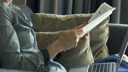 Happy, Successful Businesswoman Working With Laptop And Documents On Sofa At Home