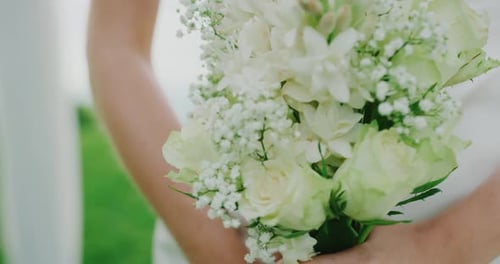 Woman Holds White Rose Bouquet at Outdoor Wedding