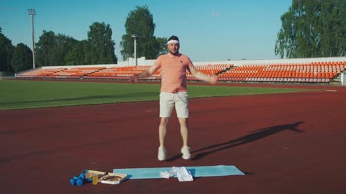 Man Doing Jumping Jacks on Track with Pizza