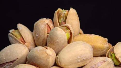 Pile of Pistachios Rotating on a Black Background