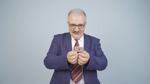 Smiling Man in Suit Using Smartphone