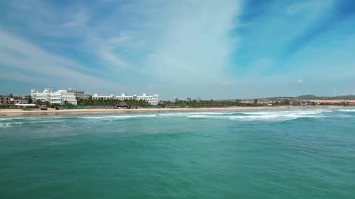 A View of the Beautiful Sea Waves Taken From a Drone Flying Over the Sea and a View of the Hotels