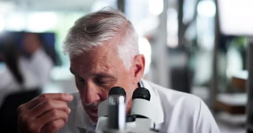 Senior Scientist Using Microscope in Modern Laboratory