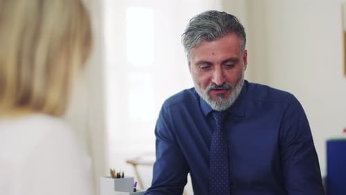 Businessman and Businesswoman Working Together in Office