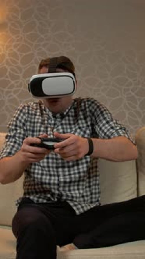 Man Using VR Headset and Controller on Couch