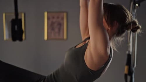 Pilates Fitness Trainer Doing Back Strengthening Exercises on in Pilates Studio Balanced Body