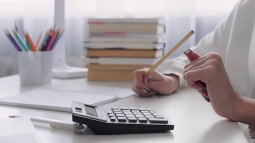 Accountant Using Calculator and Taking Notes