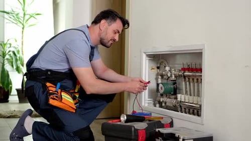 Electrician testing underfloor heating in residential building