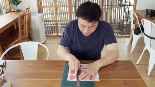 Man Making Handmade Valentines Card With Hearts