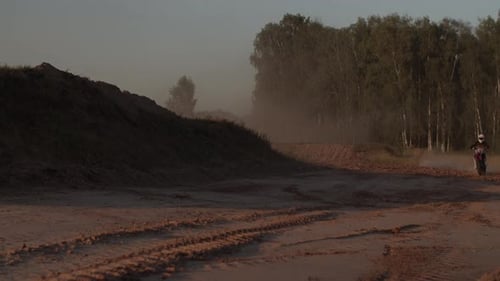 Dirt Biker Stunt on Rural Dirt Track at Sunset