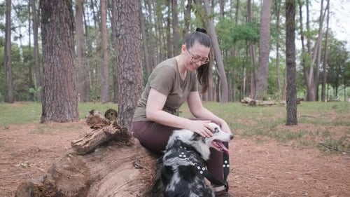 Woman Cuddles Her Dog in the Woods