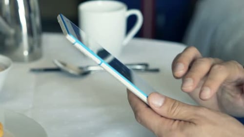 Businessman Hands With Tablet Computer By The Table During Breakfast