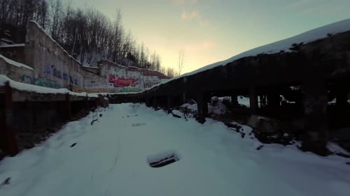 FPV drone flying along snowy brridge of abandoned Belgo Factory, Shawinigan Quebec Canada