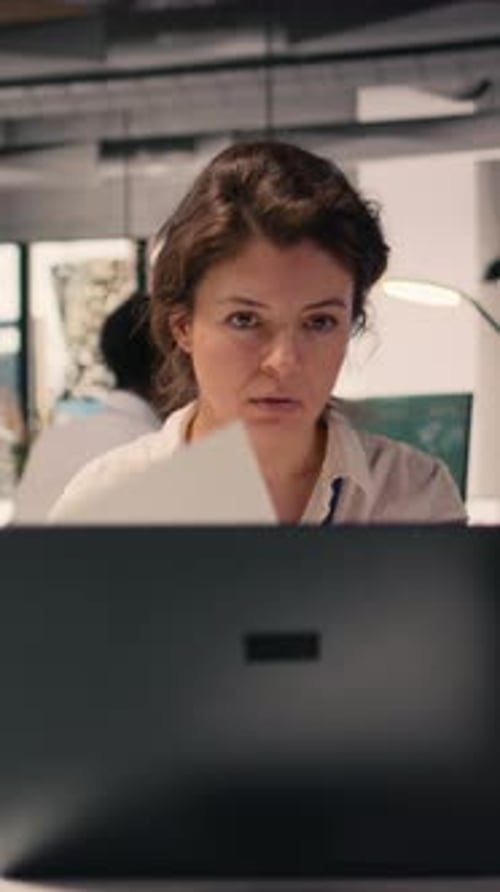 Vertical Video Businesswoman Focused on Writing Detailed Report at Office Desk