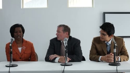 Panel of speakers at conference table speaking