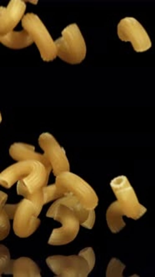 Dry Pasta Falls on the Black Table Filmed on a Highspeed Camera at 1000 Fps