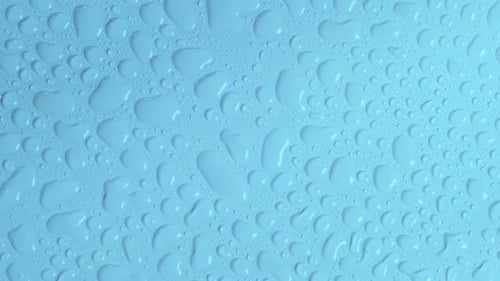 Rotating Light Blue Pastel Background with Water Drops or Transparent Cosmetic Gel Fluid Hyaluronic