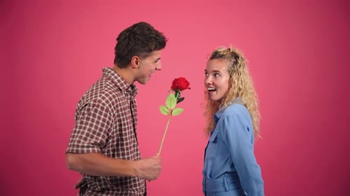 Young Man Gives Woman a Rose and Hugs