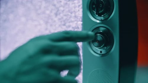 Old Television Showing Flickering Static in Closeup View Finger Touching Panel