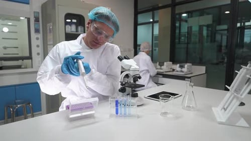 Scientist Using Pipette and Microscope in Modern Laboratory