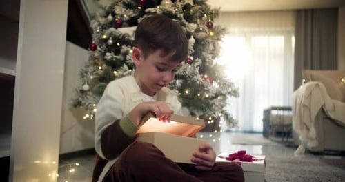 Excited Child Opens Glowing Christmas Present At Home