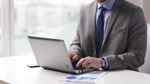 Professional Man Typing on Laptop in Bright Office