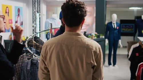 Customers and Employee Discuss Clothing in Retail Store