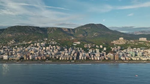 Aerial View City on Horizon Flanked By Stunning Mountain Ranges