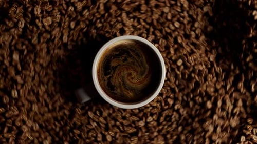 Coffee cup sliding over a bed of beans.