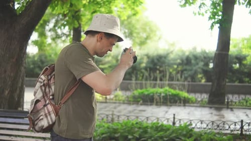 Adult Male Tourist Photographer Wearing a Panama Hat and Carrying a Backpack Enthusiastically
