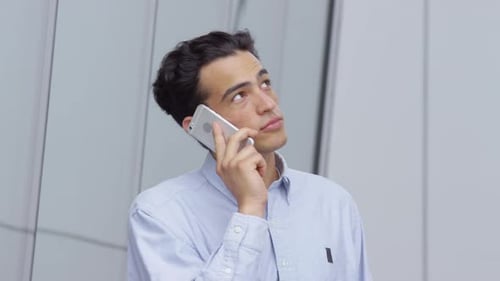 Young Man Talking on Phone Outdoors in Daytime