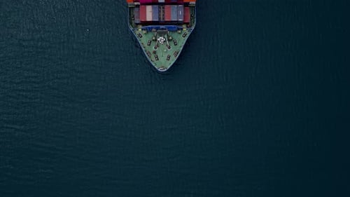 Aerial View of a Cargo Ship Navigating Calm Waters with Colorful Shipping Containers During Daylight